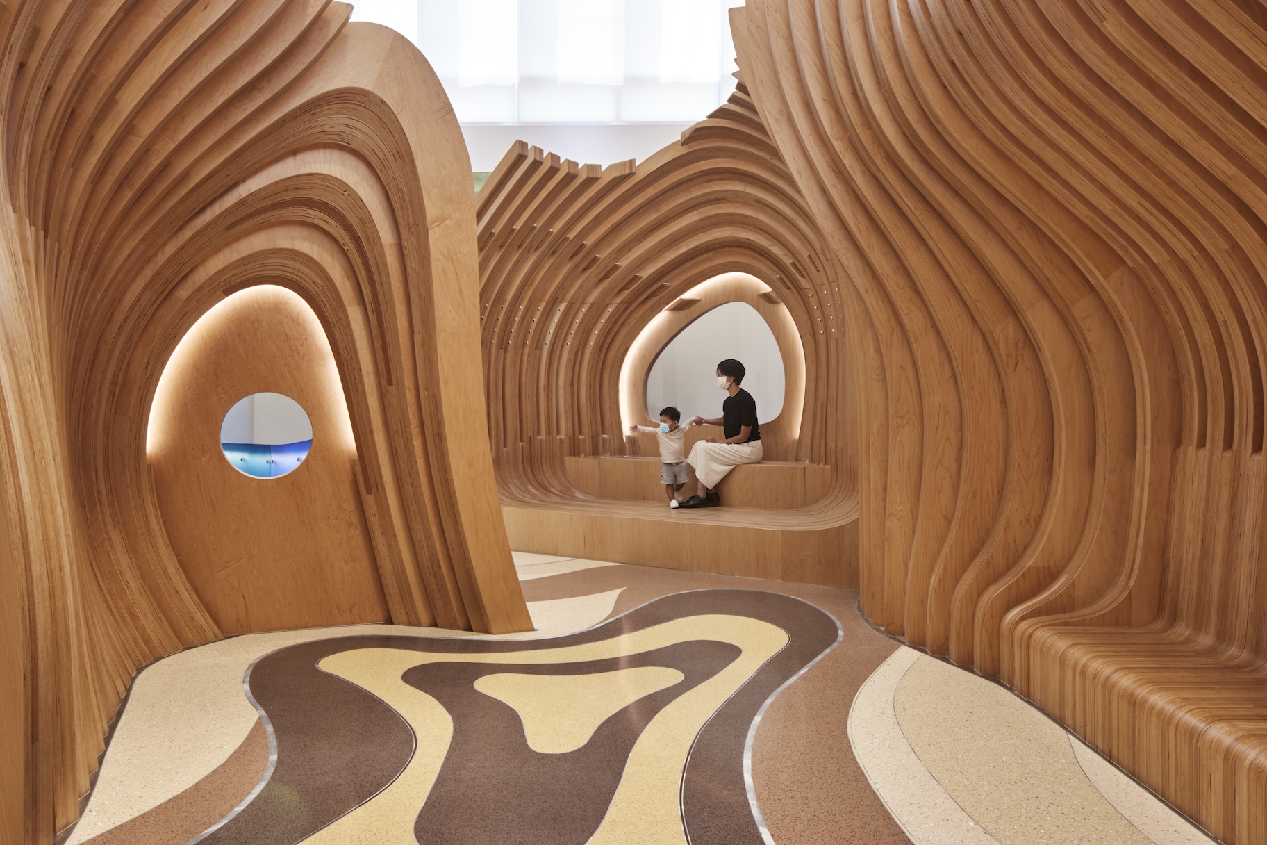 Woman and child sitting inside custom furniture at Boston Children’s Hospital