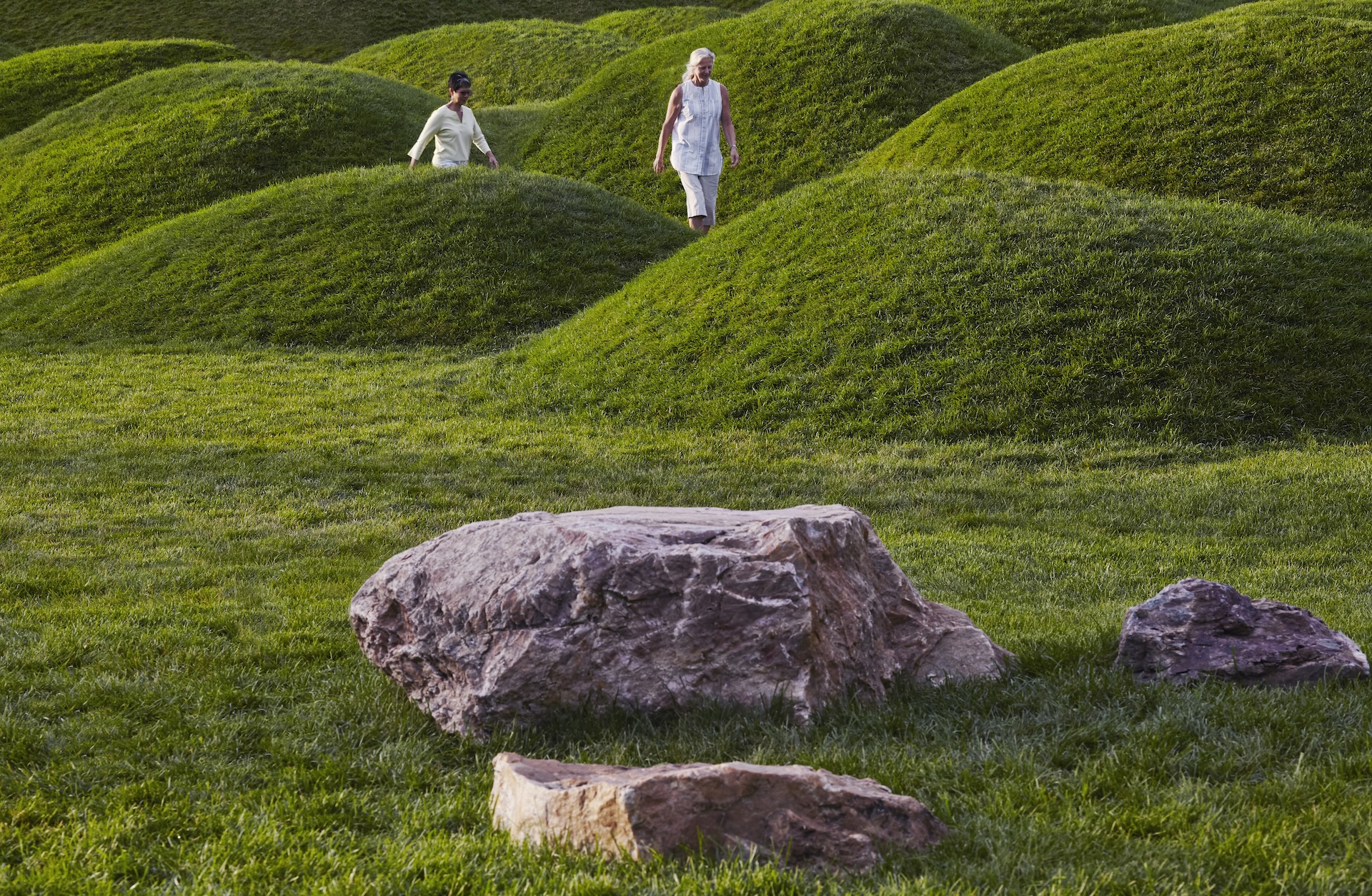 Two women walking through grassy hills of the Chicago Botanic Garden Learning Campus