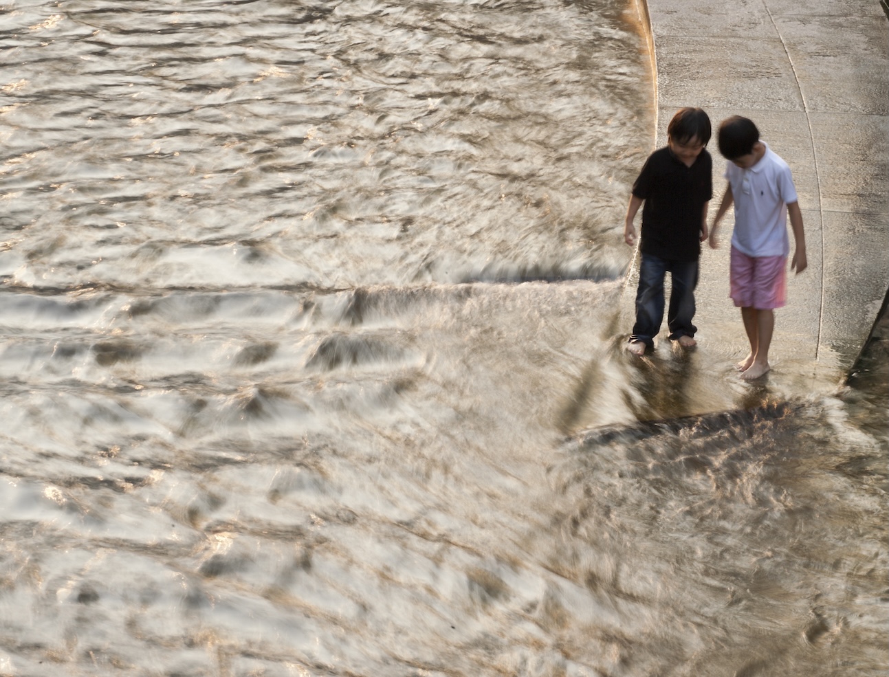 Two young boys standing at the Cheonggye River Source Point in Seoul, South Korea